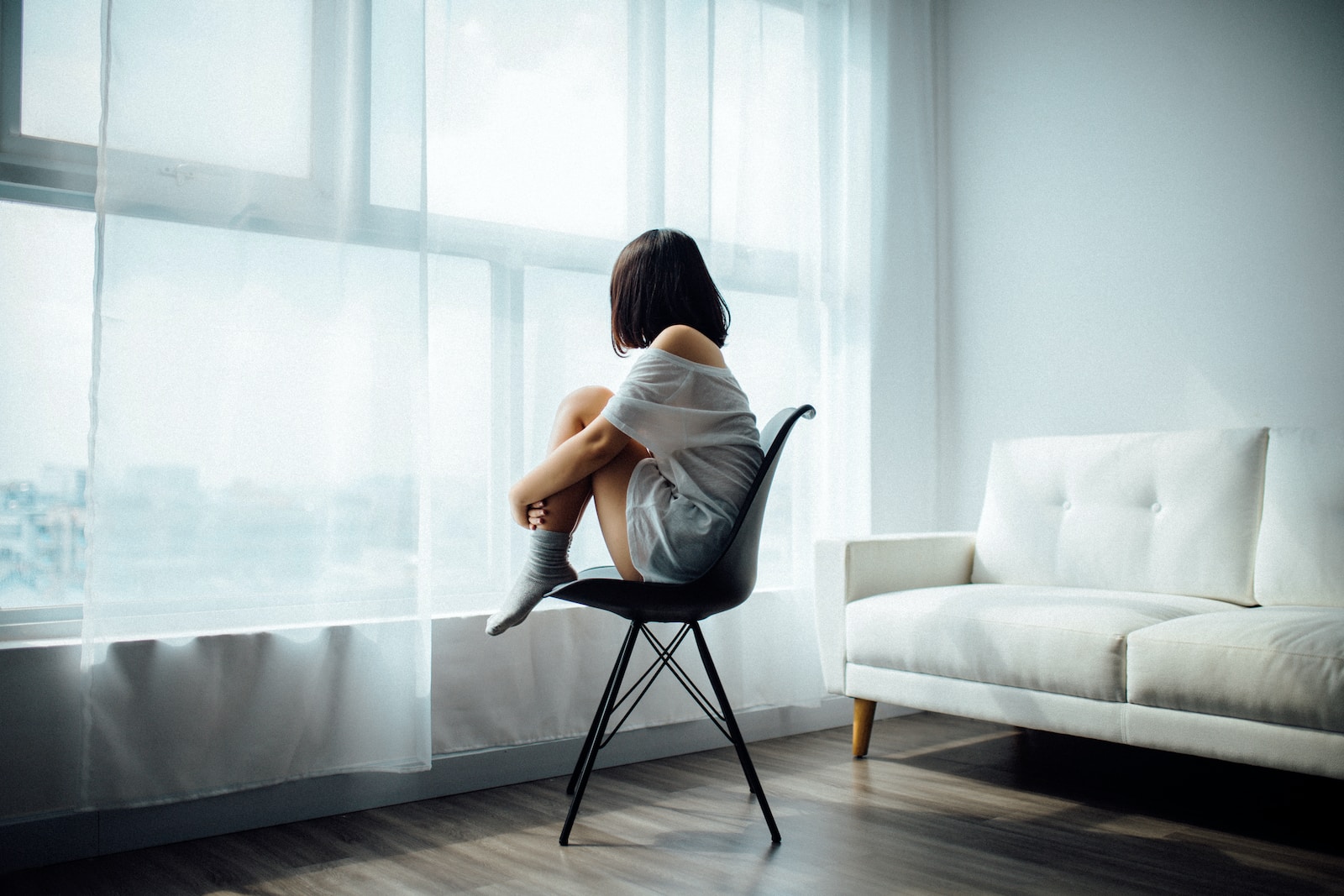 Image of a person looking out a window with a thoughtful expression